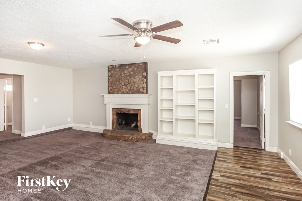 a living room with a fireplace and a ceiling fan