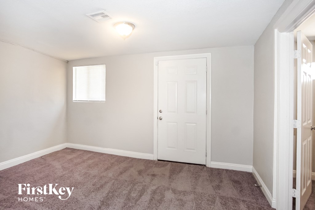 a bedroom with a white door and a carpeted floor