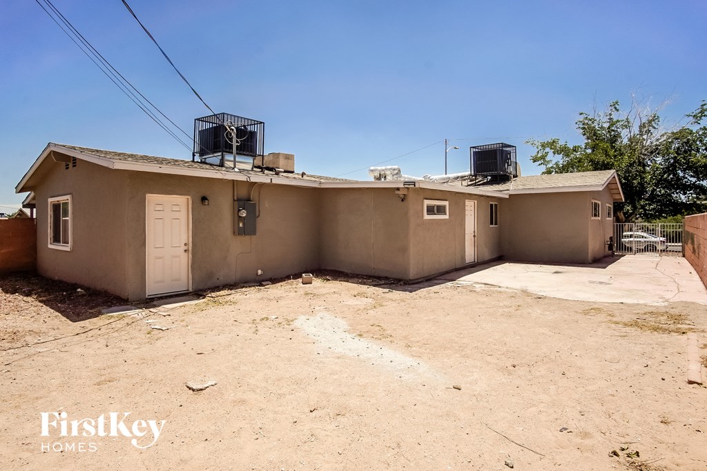 a home with a dirt lot and a house with two water tanks on the roof