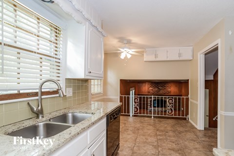 A kitchen with a sink and a window with blinds.