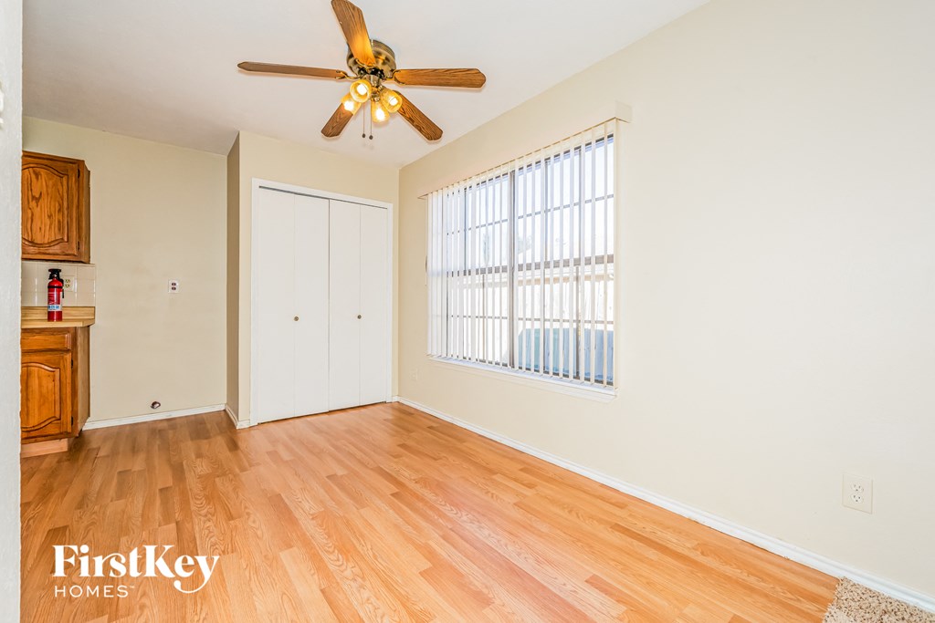 a living room with wood floors and a ceiling fan
