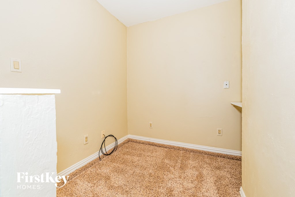 a empty room with a carpeted floor and a white wall
