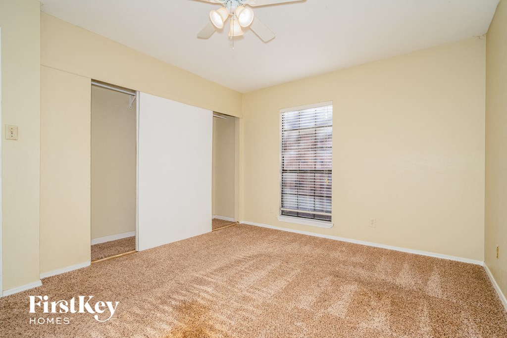 an empty living room with a closet and a window