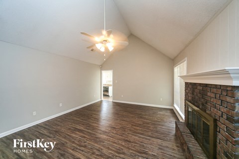 A room with wooden floors and a brick fireplace.