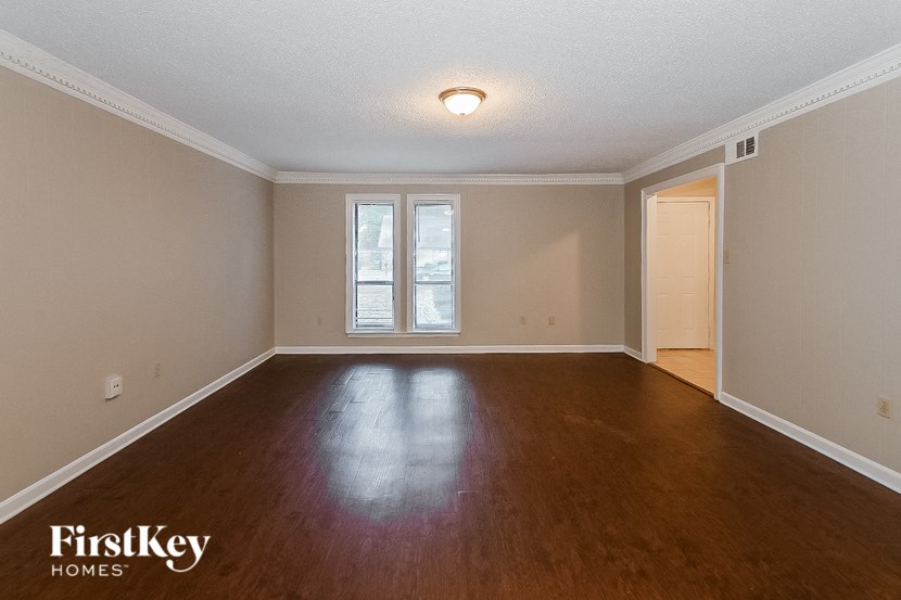 a empty living room with wood floors and a window
