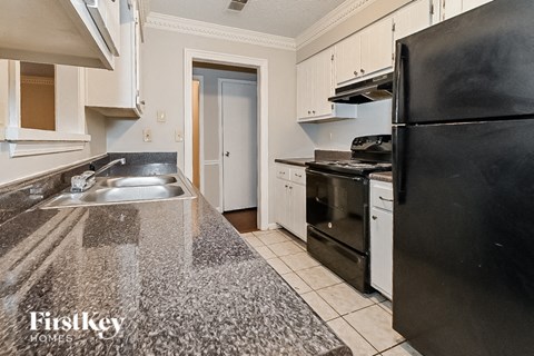 a kitchen with granite counter tops and black appliances
