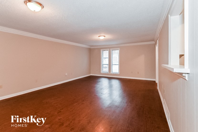 a empty living room with wood floors and a window