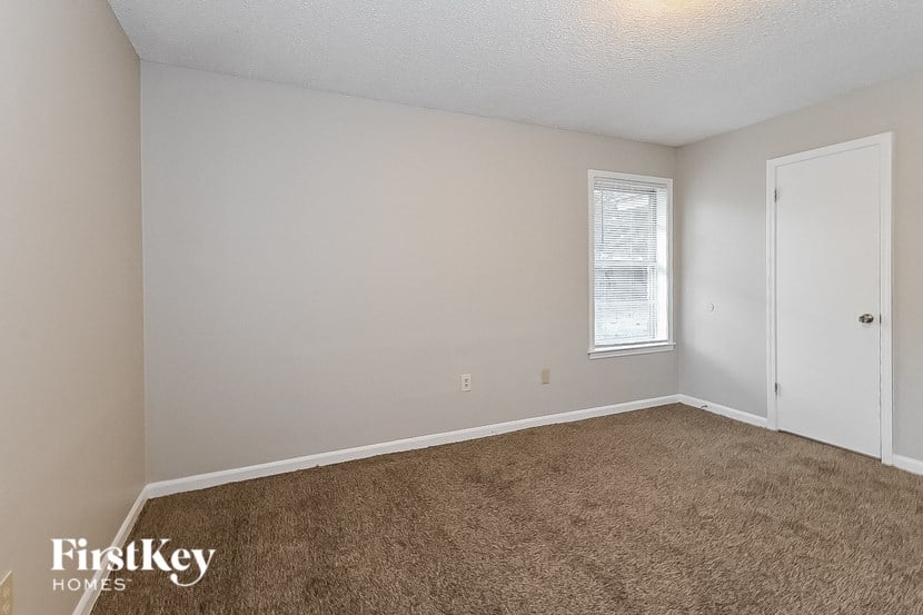 a bedroom with a carpeted floor and a window