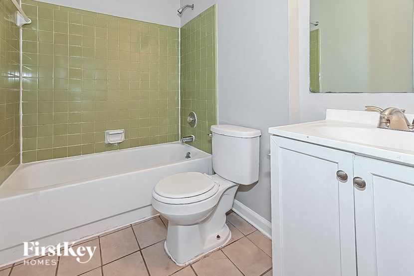 a bathroom with a toilet and a tub and a sink