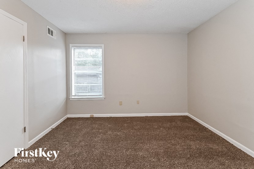 a bedroom with a carpeted floor and a window