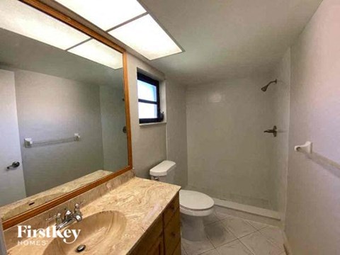 A bathroom with a wooden vanity and a toilet.