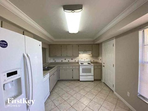 A kitchen with white appliances and cabinets.