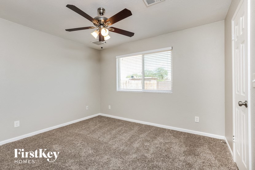 a bedroom with a ceiling fan and a window