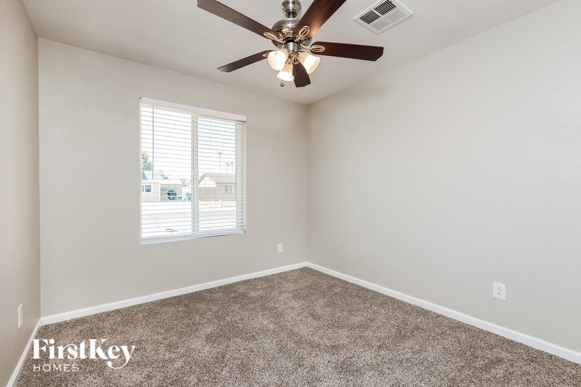 a bedroom with a ceiling fan and a window