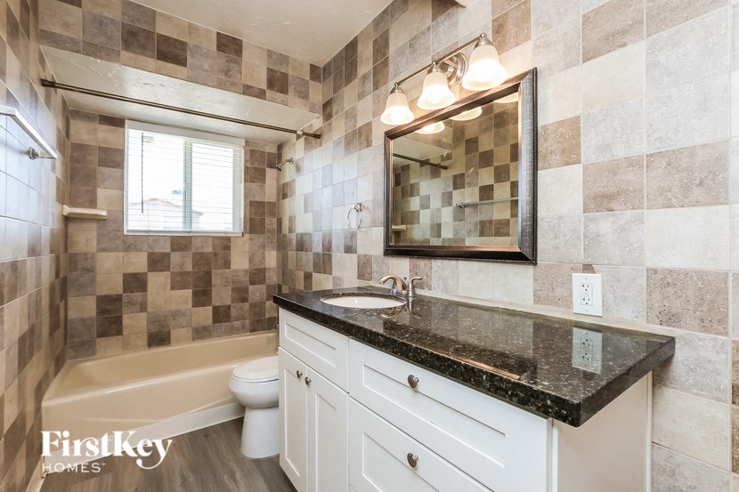 a bathroom with a sink and a toilet and a bath tub