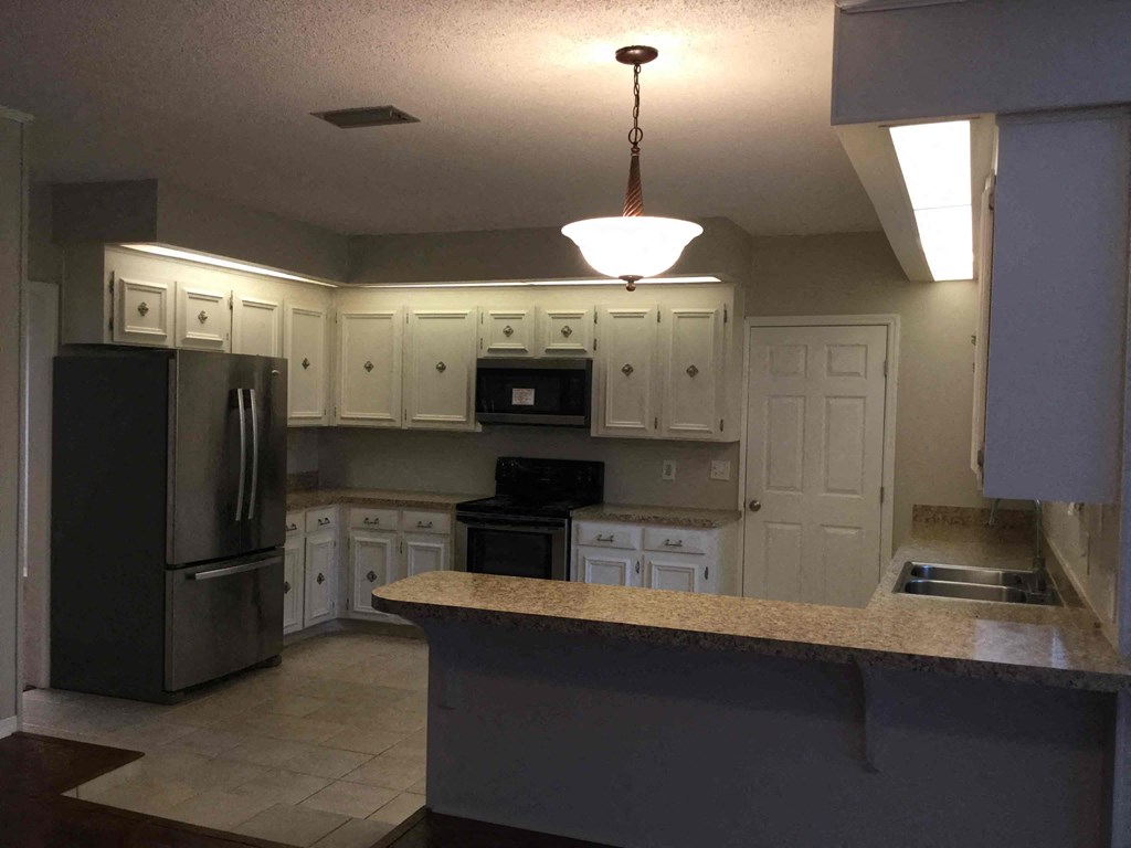 a kitchen with white cabinets and a counter top