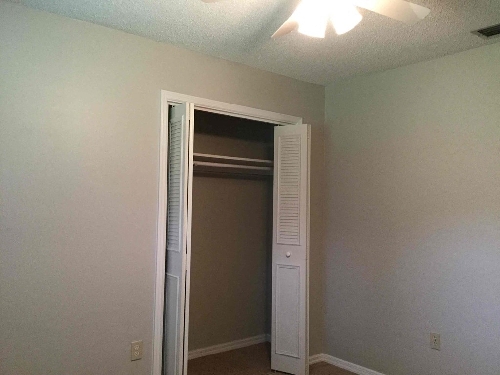 an open closet door in a room with a white closet