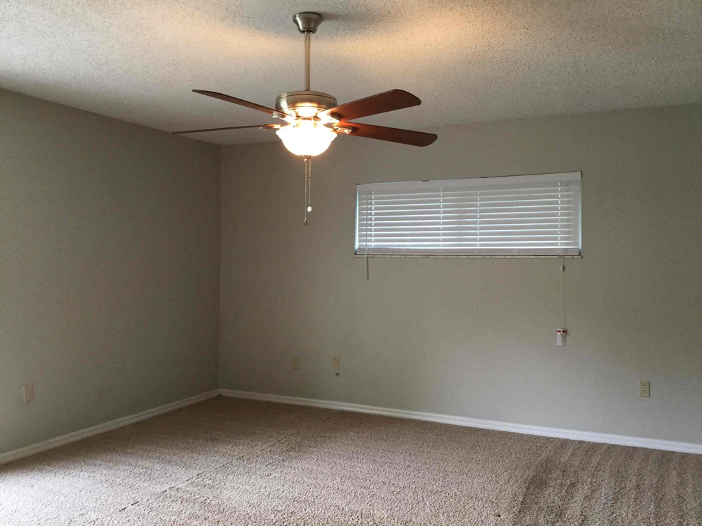 a bedroom with a ceiling fan and a window