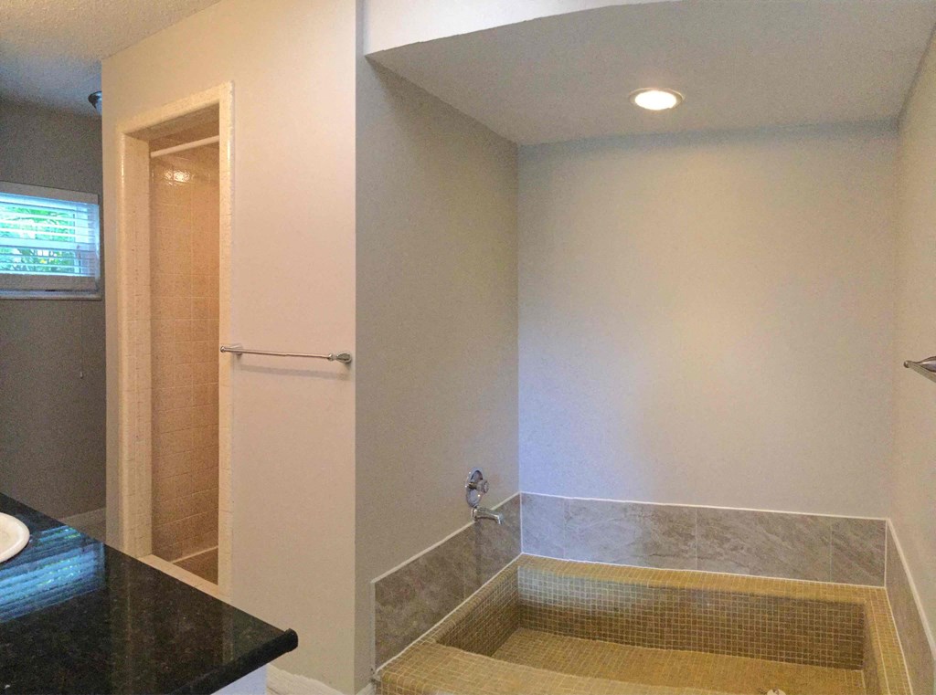 a bathroom with a tub and a shower and a sink