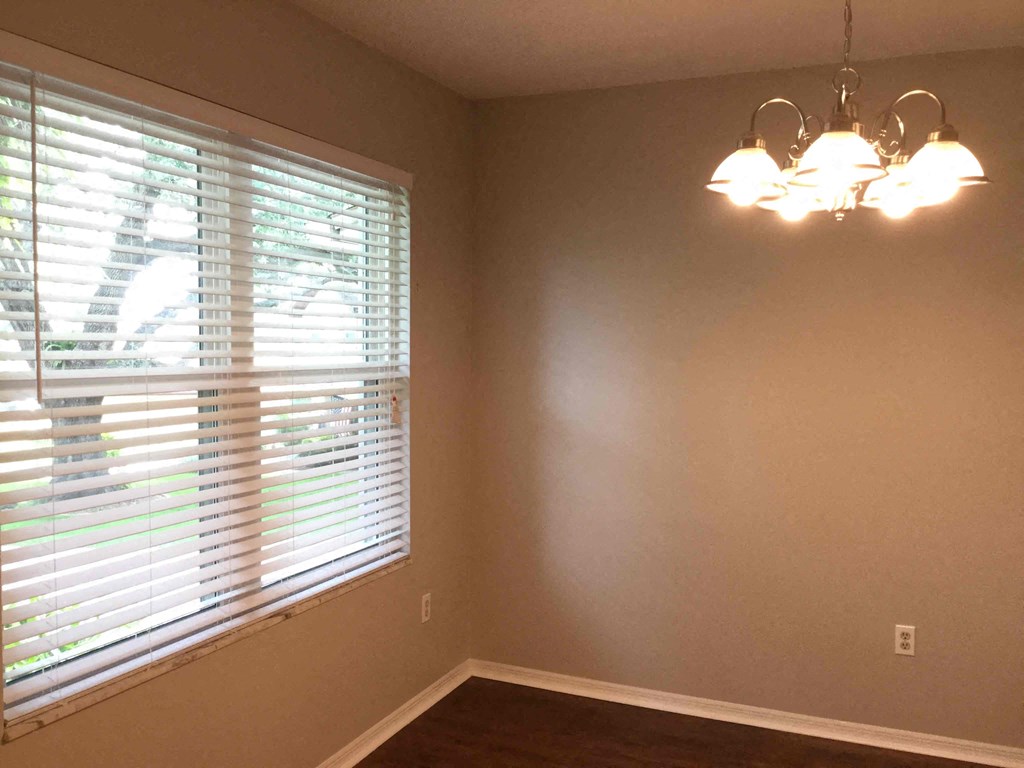 a dining room with a large window and a chandelier