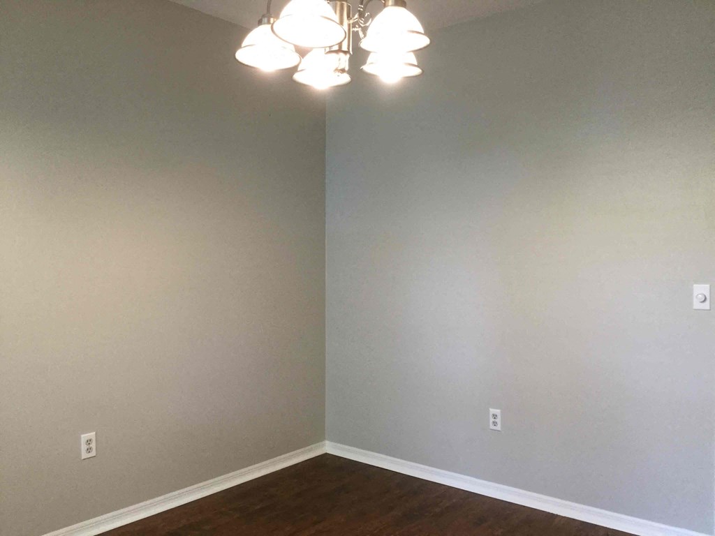 a corner of a room with white walls and lamps