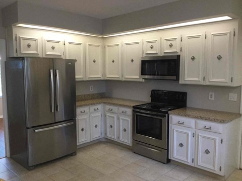 a kitchen with white cabinets and stainless steel appliances