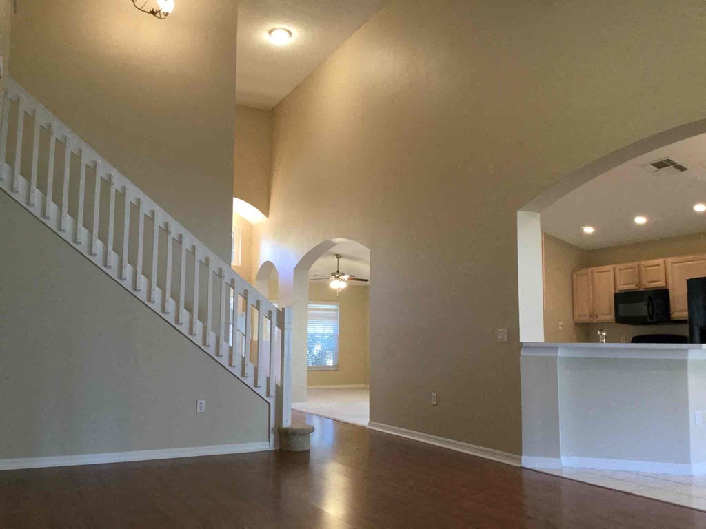 A spacious living room with a staircase leading to the upper floor.