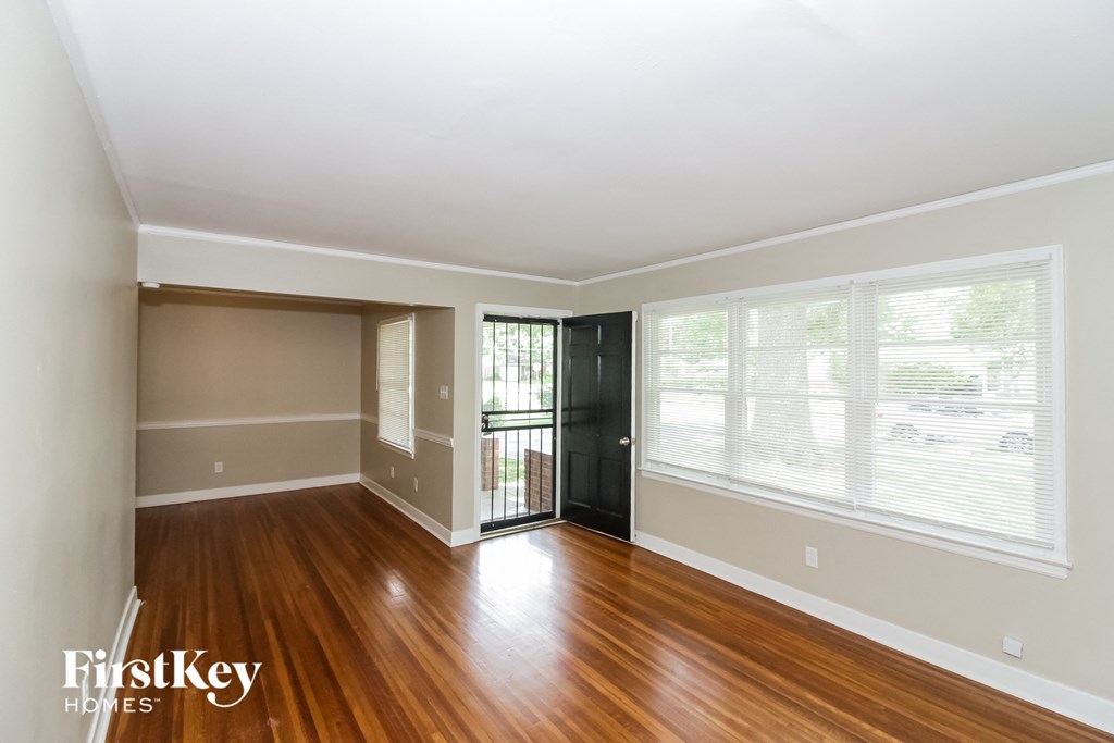 A room with wooden floors and a black door.
