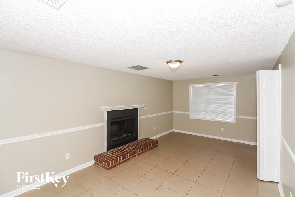 A living room with a fireplace and a window.