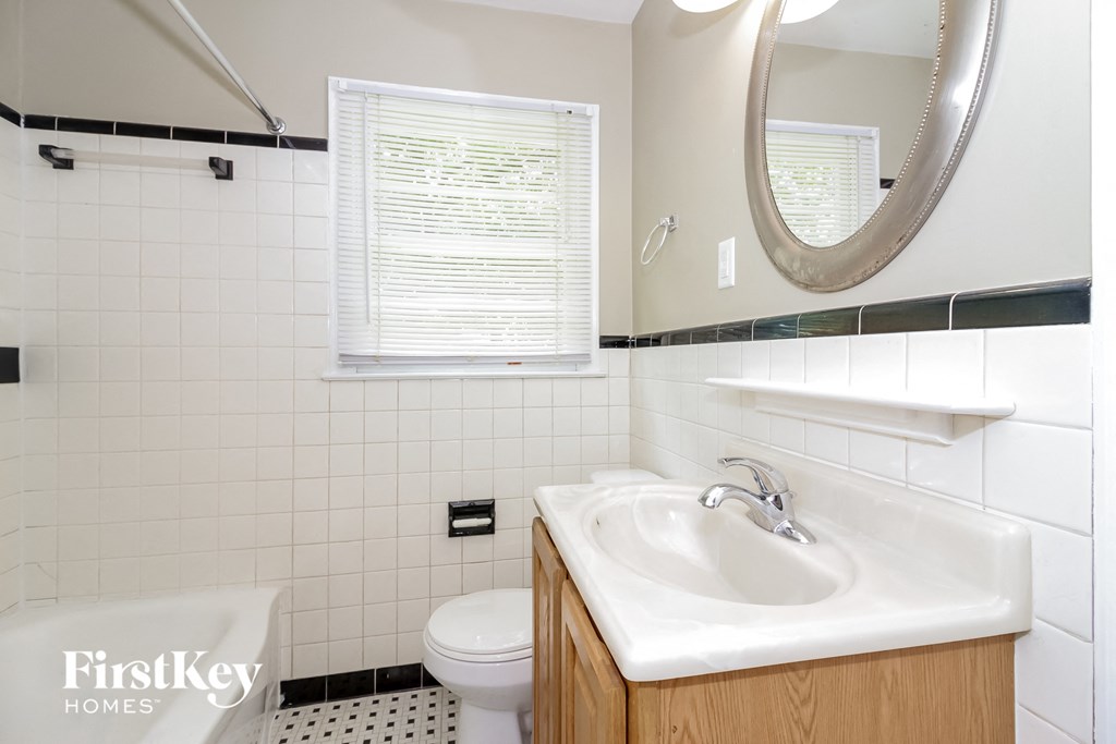 A bathroom with a white sink and a toilet.