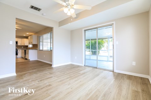A spacious room with wooden flooring and a ceiling fan.