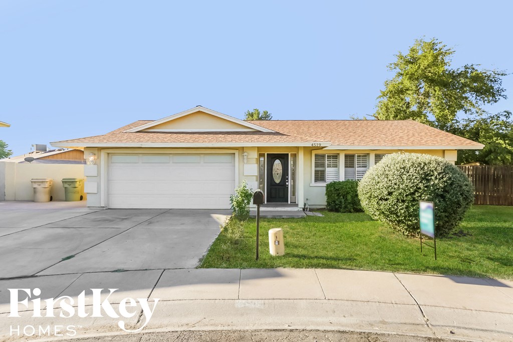 a small yellow house with a white garage door