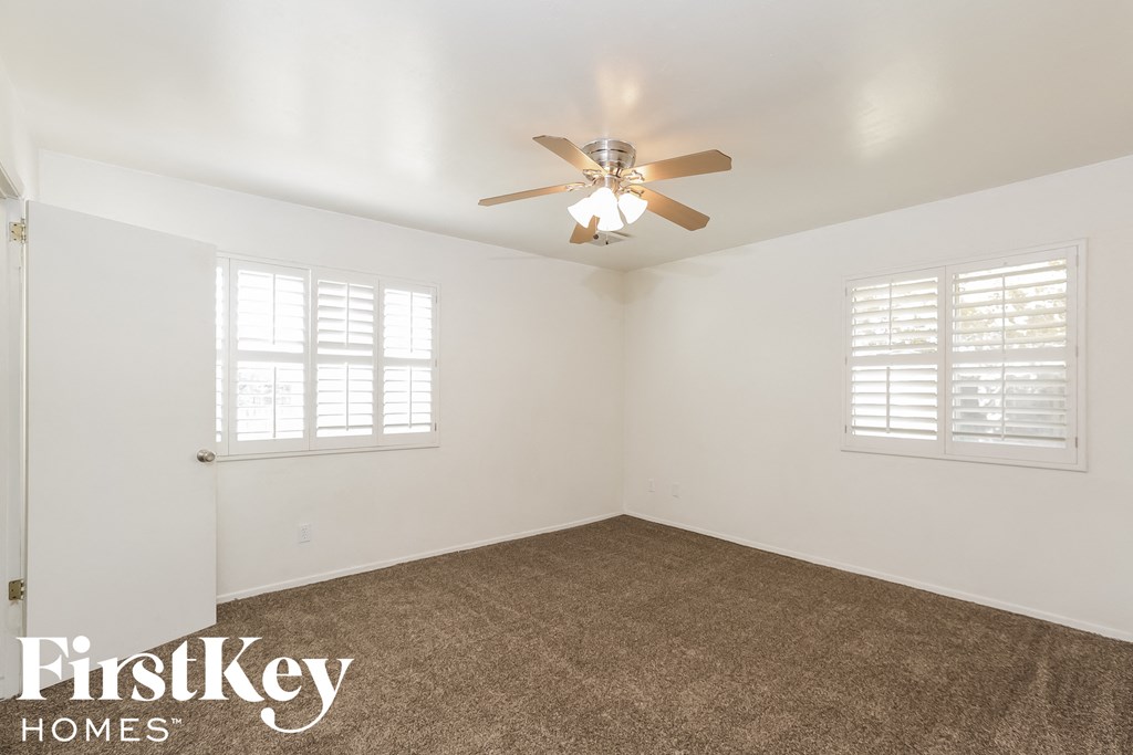a bedroom with a carpet and a ceiling fan