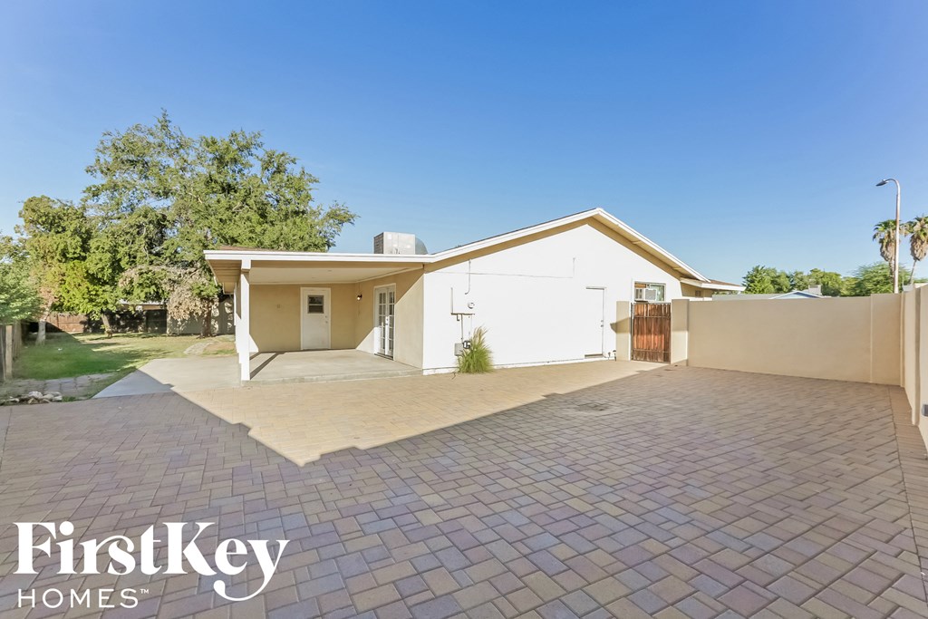 a home with a brick driveway and a white house
