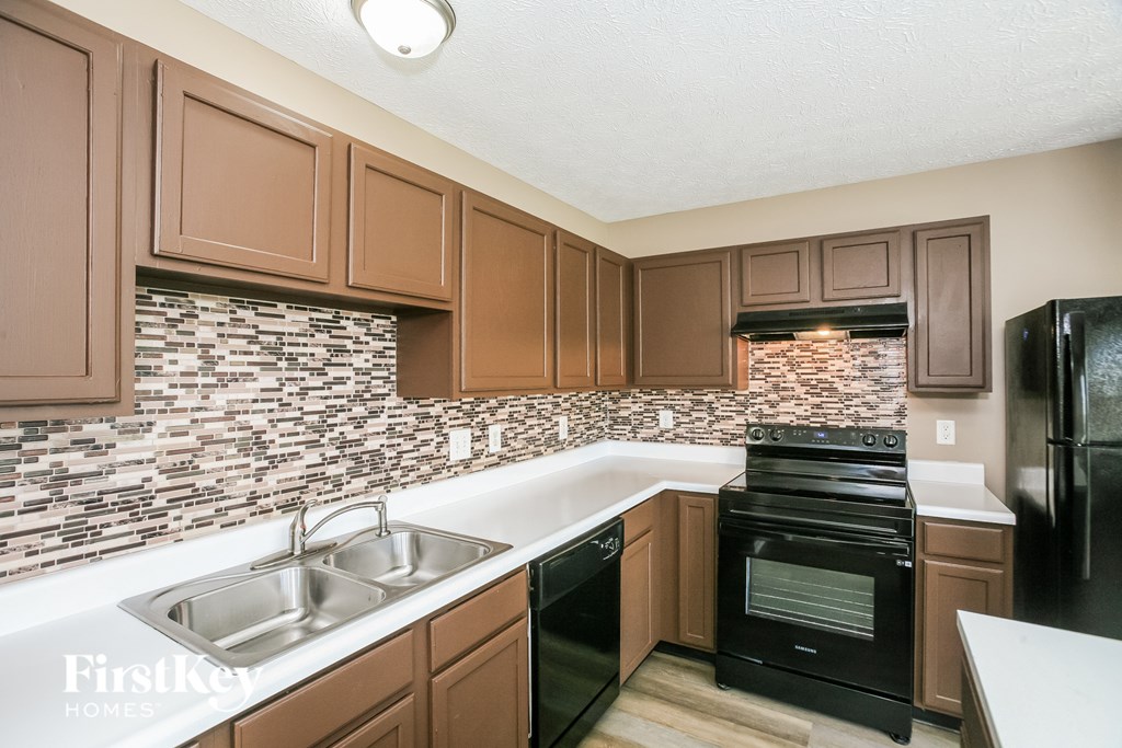 A kitchen with brown cabinets and a black oven.