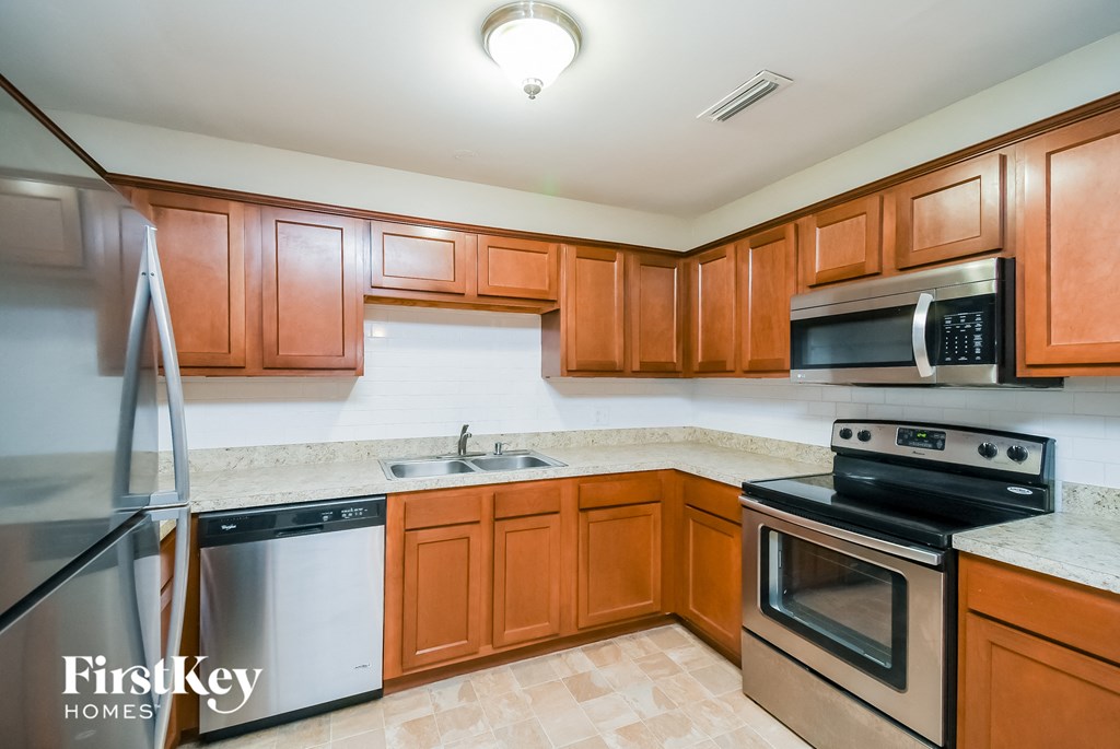 a kitchen with wooden cabinets and stainless steel appliances