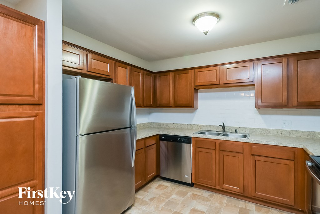 a kitchen with wooden cabinets and a stainless steel refrigerator