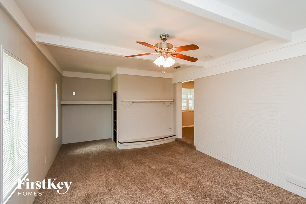 a living room with a ceiling fan and a closet