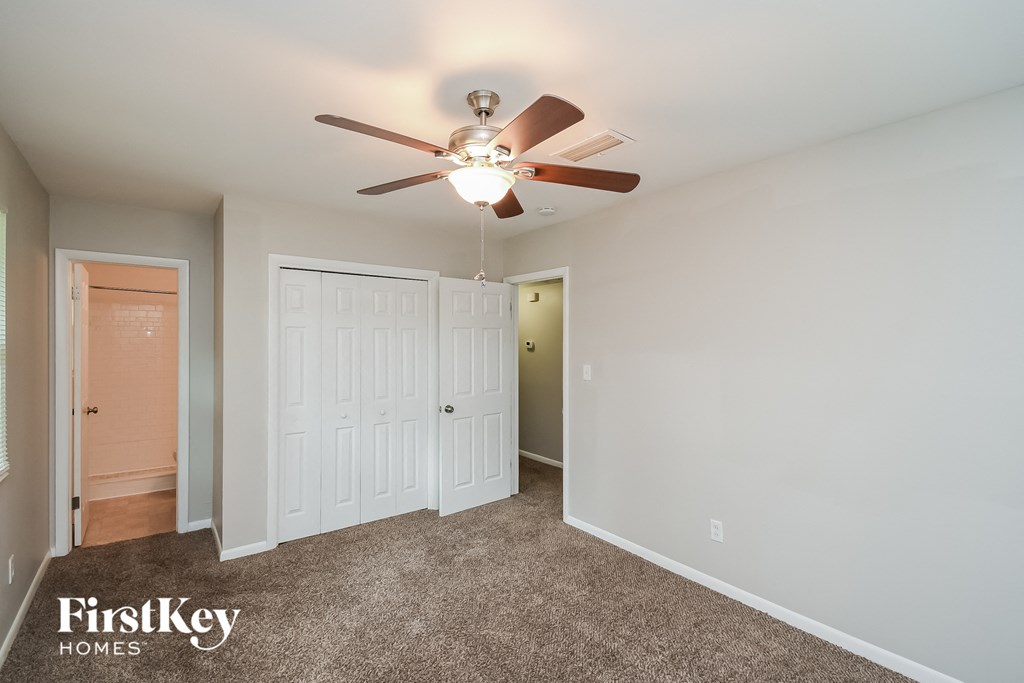 a bedroom with a ceiling fan and a closet