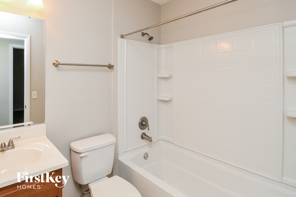 a white bathroom with a tub and a toilet and a sink