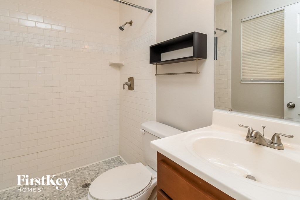 a bathroom with a sink toilet and a mirror