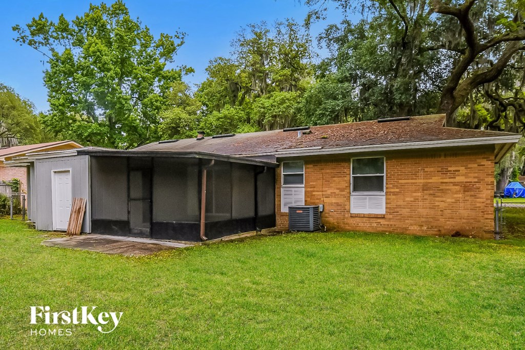 a brick house with a garage and a yard with a tree