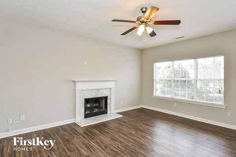 a living room with a fireplace and a ceiling fan
