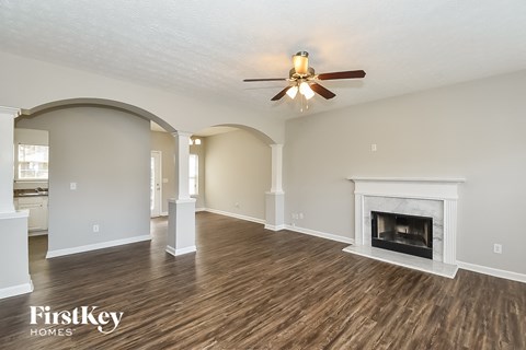 a living room with a fireplace and a ceiling fan