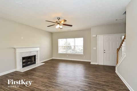 a living room with a fireplace and a ceiling fan
