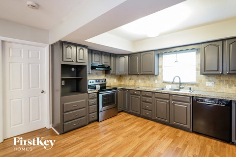 A kitchen with wooden floors and a white door.