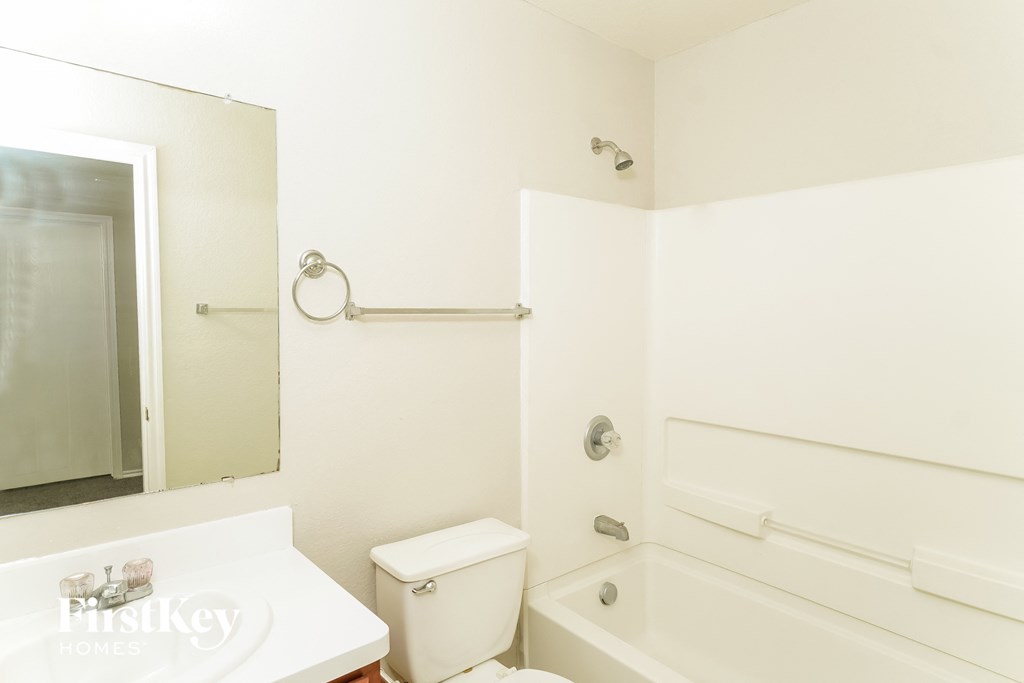 a white bathroom with a tub and a toilet and a sink