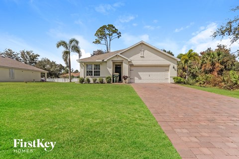 a house with a driveway and a lawn in front of it