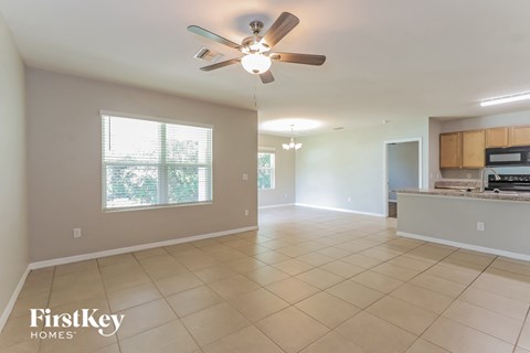 an empty kitchen and living room with a ceiling fan