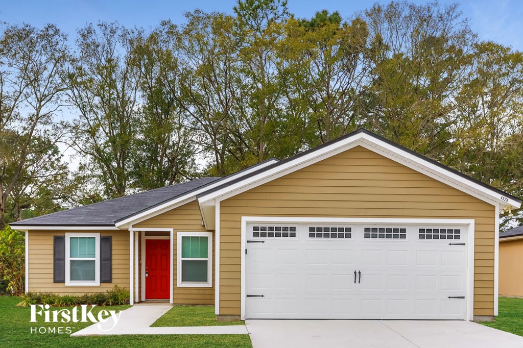 a small yellow house with a white garage door